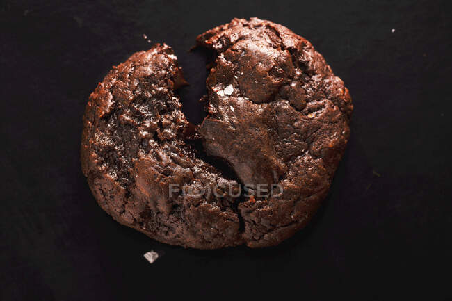Broken soft chocolate cookie with salt flakes — Stock Photo