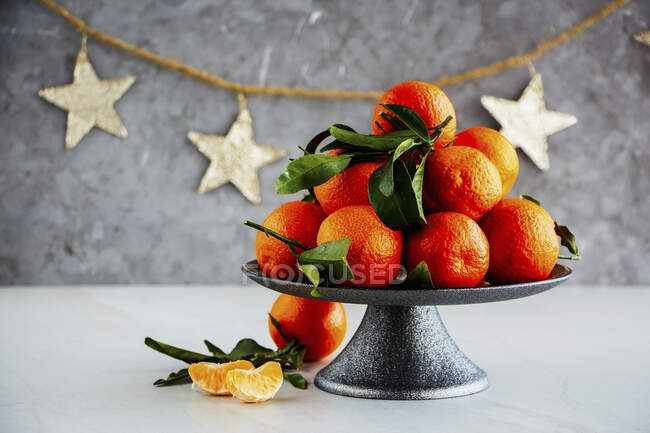 Mandarinas maduras cítricos con hojas y decoración navideña - foto de stock