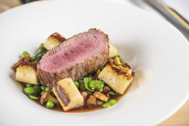 Beef fillet with beans and chanterelle mushrooms — Stock Photo