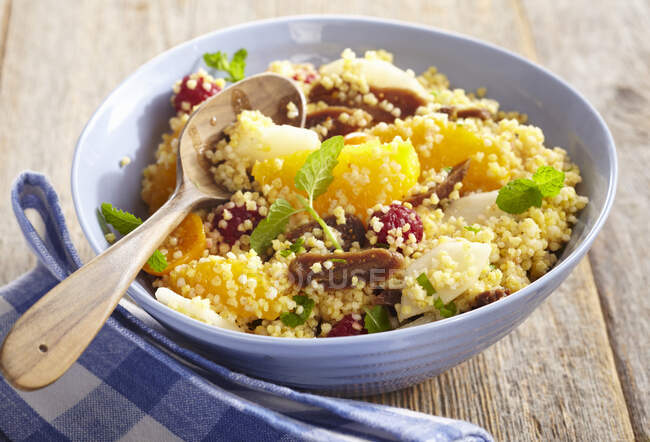 Fruity millet salad with orange, fig, pear, physalis and raspberries — Stock Photo