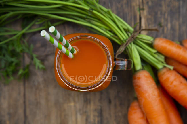 A carrot smoothie with straws in a tankard — Stock Photo