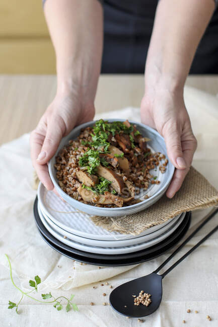 Mushrooms with Buckwheat on Plate in Female Hands — Photo de stock