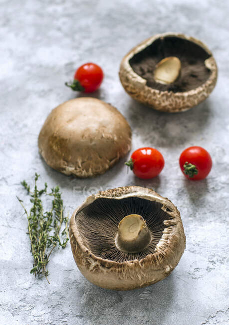 Cogumelos portobello crus, raminhos de tomilho e tomates cereja — Fotografia de Stock
