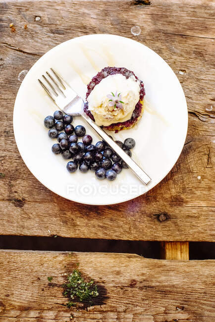 Shorcake de style sudiste avec compote de bleuets, crème glacée vanille, bleuets frais et fleurs comestibles avec bruine de miel — Photo de stock