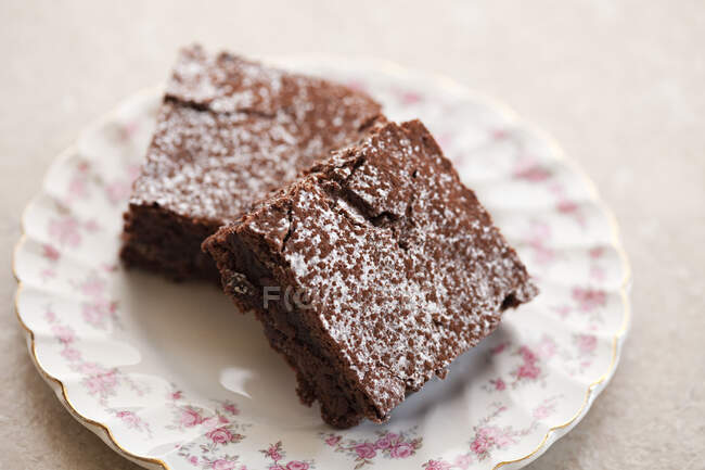 Chocolate brownie dusted with icing sugar — Stock Photo