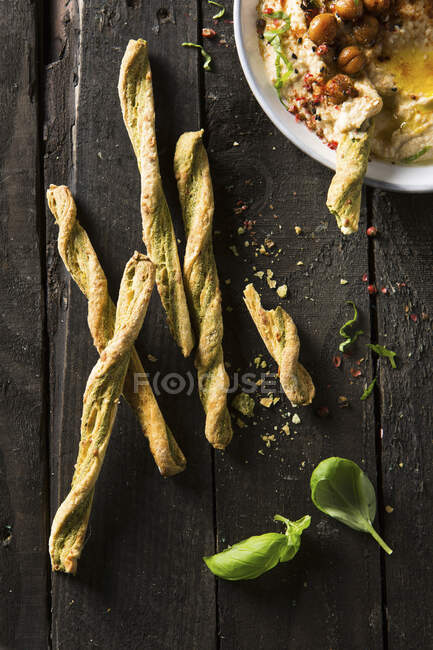 Basil and parmesan breadsticks with hummus dip — Stock Photo