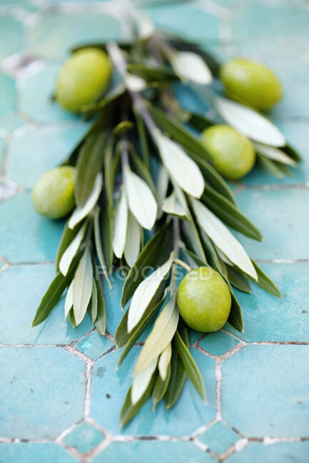 Olive verdi e olio d'oliva su fondo ligneo — Foto stock