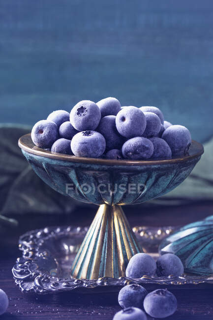 Frozen blueberries in vintage metal bowl — Stock Photo