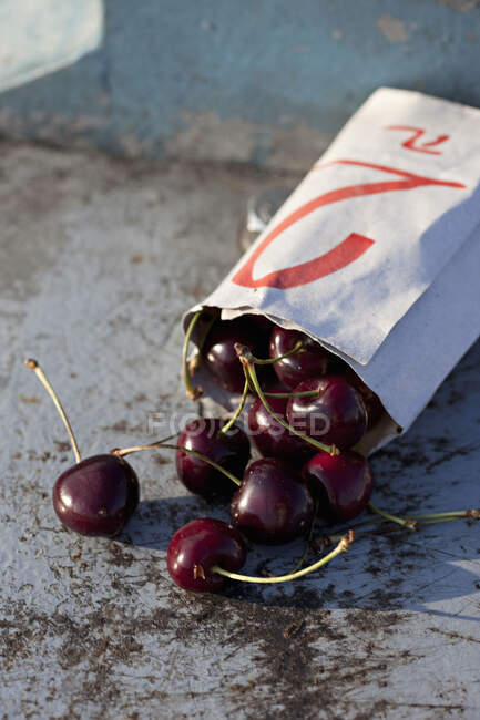 Cherries cascading out of a bag — Stock Photo