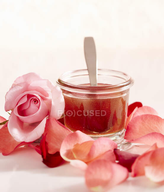 Rose miel gagner un pot avec de l'eau de rose et pétales de rose séchés — Photo de stock
