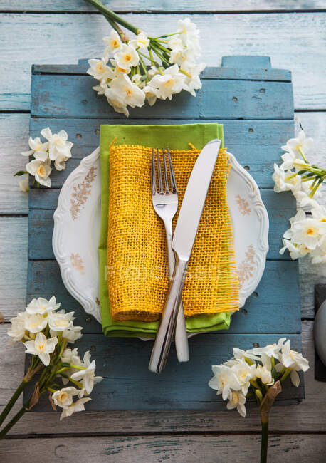Ajuste de mesa de primavera - flor narciso, tenedor y cuchillo en la mesa de Pascua - foto de stock