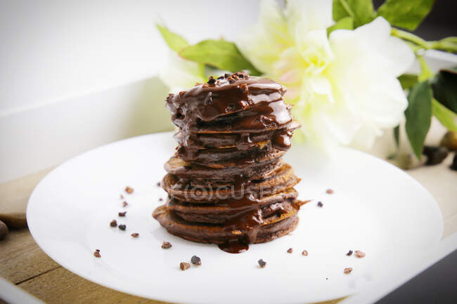 A stack of chocolate pancakes with chocolate sauce — Photo de stock