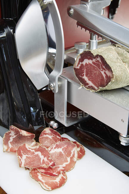 Cured ham being finely sliced — Stock Photo