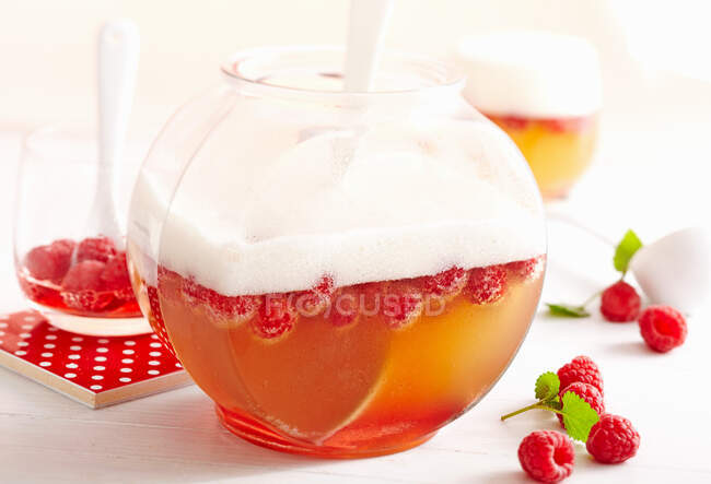 Wheat peach punch with raspberries in big jar — Stock Photo