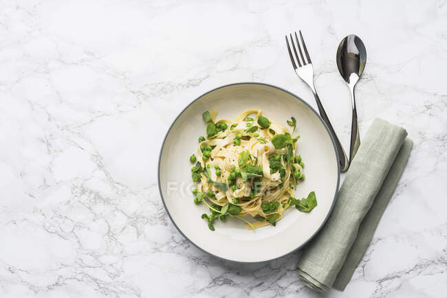 Tagliatelle with peas and a creamy sauce — Stock Photo