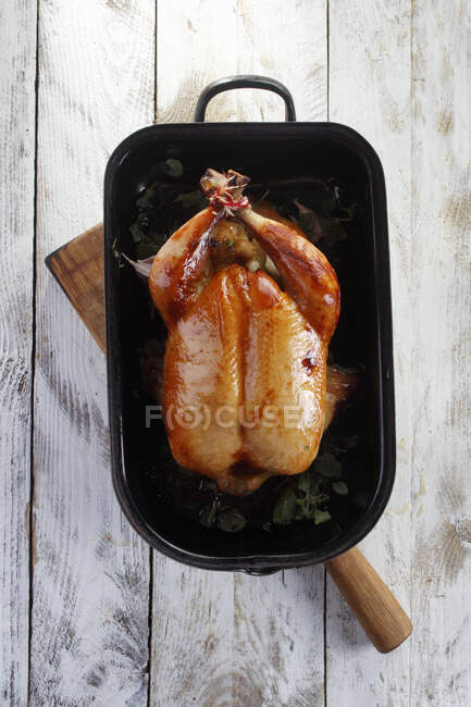 Pollo arrosto in un piatto nero — Foto stock