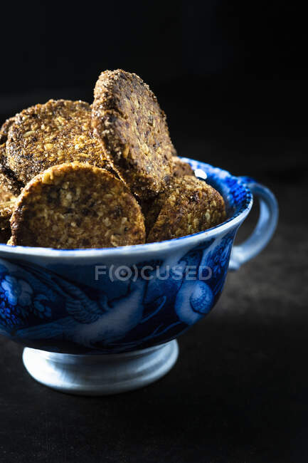 Biscoitos temperados com nozes, tâmaras e flocos de coco em xícara azul — Fotografia de Stock