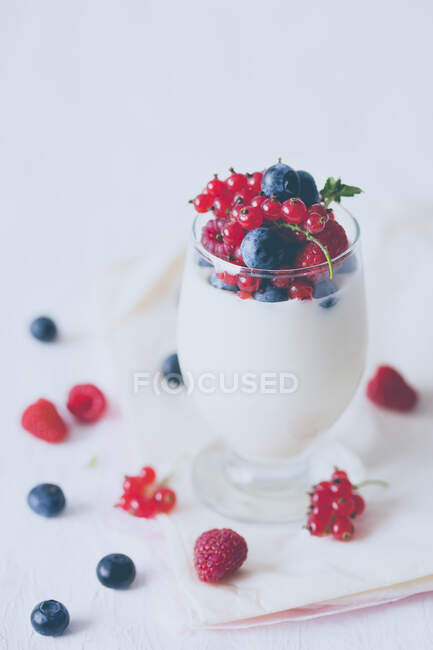 Coconut and white chocolate mousse with berries in a glass — Stock Photo