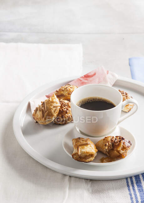 Pasteles de manzana pequeños con miel y almendras, servidos con café - foto de stock