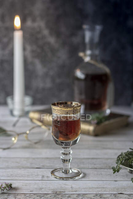 Licor de ervas em um copo com uma borda dourada — Fotografia de Stock