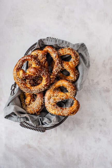 Homemade pretzels with seasme seeds in a wire basket — Stock Photo