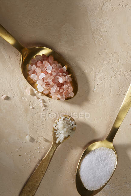 Pink celtic and table salt on spoons — Stock Photo