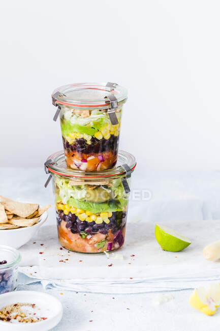 Layered Mexican salads in jars — Stock Photo