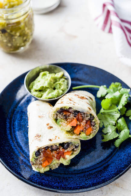 Burrito vegetariano con frijoles negros y guacamole - foto de stock