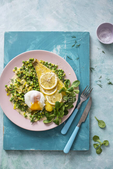 Geräucherter Schellfisch auf einem Erbsenbett mit welkem Edelsalat, Lauch und pochiertem Ei — Stockfoto