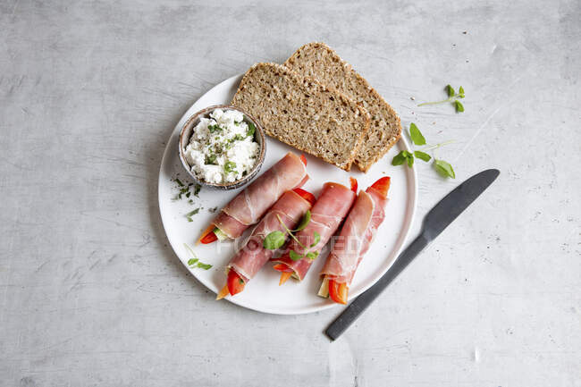Raw ham and vegetable rolls with cream cheese and wholemeal bread — Stock Photo