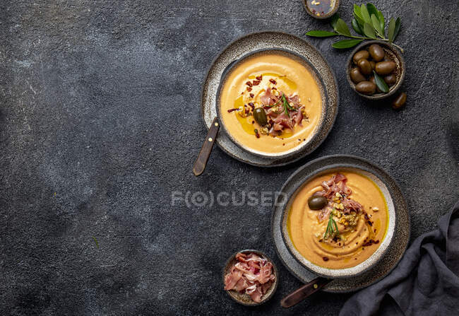 Sopa fría de tomate español Salmorejo servido con jamón serrano y aceitunas - foto de stock