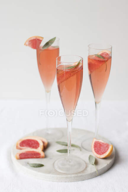 Fresh grapefruit juice with lemon and mint on white background — Stock Photo