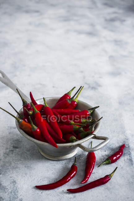 Red chilli peppers on white table — Stock Photo