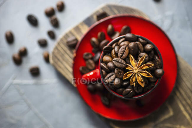 Rustic ceramic cup full of raw coffee beans - foto de stock
