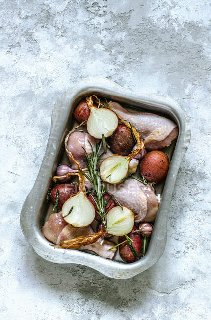 Chicken legs with garlic, onion peel, rosemary, spices the mould before baking - foto de stock