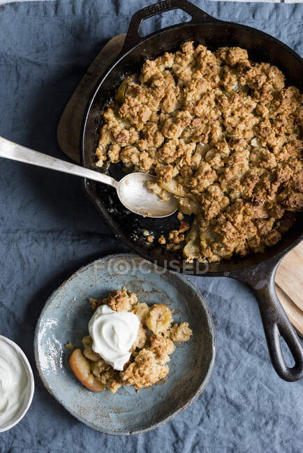 Apple and banana oat crumble with almonds served with greek yogurt — Stock Photo