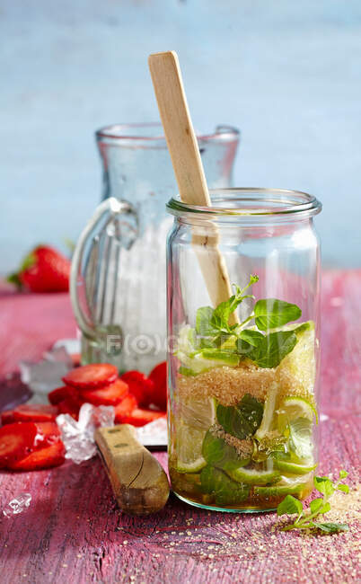 Ponche con fresas, limas, menta y azúcar morena - foto de stock