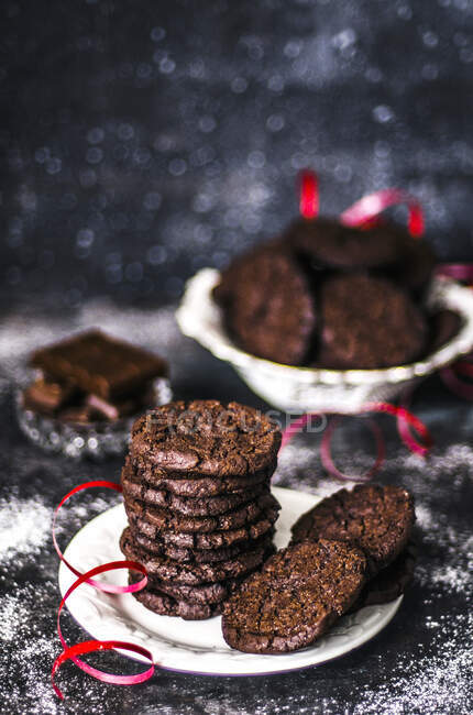 Chocolate cookies with red ribbon on plate — Photo de stock