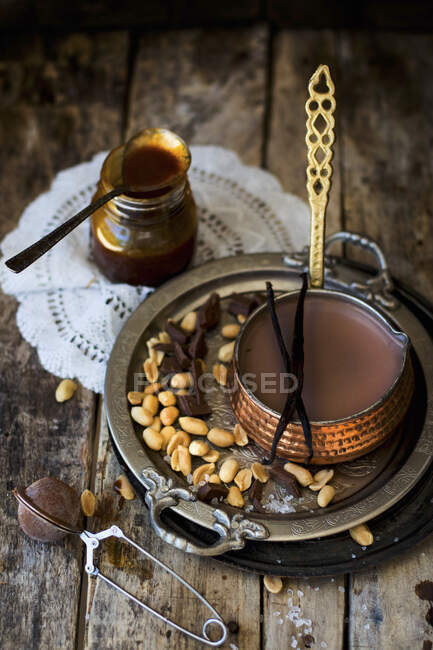 Горячий шоколад с арахисовой карамелью в медной сковороде — стоковое фото