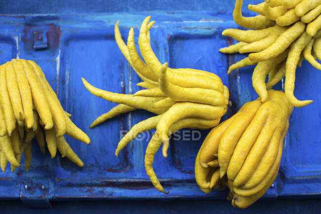 Primer plano de deliciosos limones dedo sobre un fondo azul - foto de stock