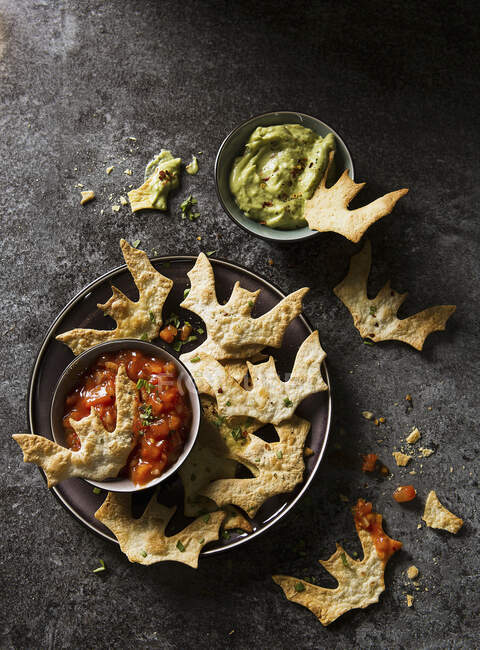 Halloween bat torilla chips with tomato and guacamole dip — Stock Photo