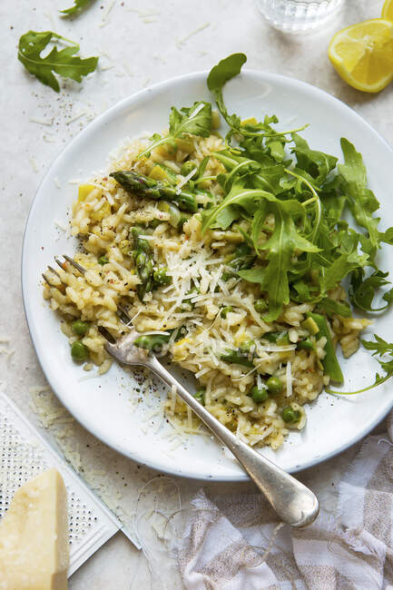 Risotto with peas, asparagus and rocket salad with parmesan — Stock Photo