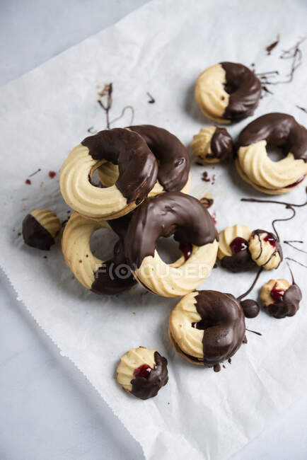 Sugar biscuits with chocolate glazing on baking paper — Stock Photo