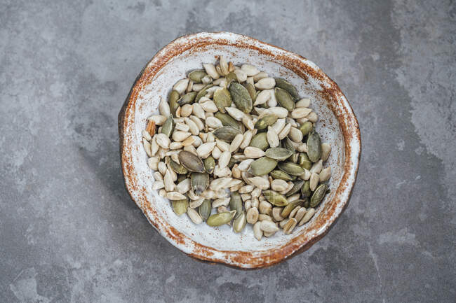 Calabaza asada y semillas de girasol en un tazón hecho a mano - foto de stock