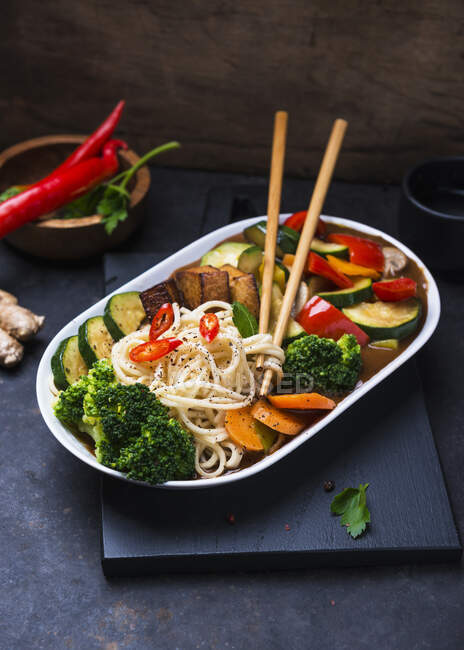 Восточная лапша с овощами и жареным тофу в сычуаньском соусе — стоковое фото