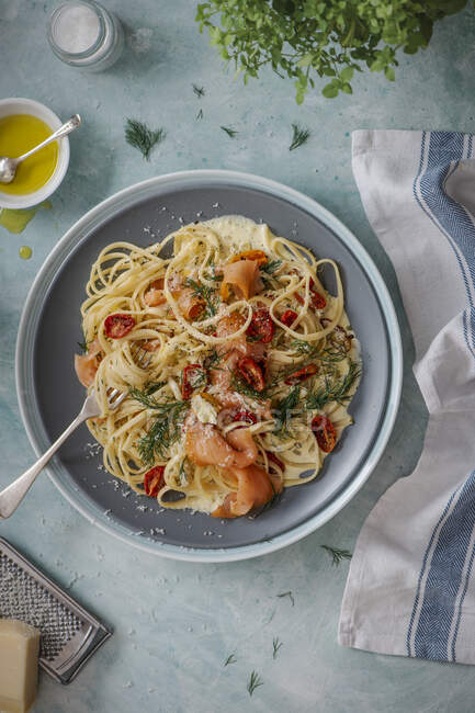 Smoked salmon pasta with creamy dill and garlic sauce, roasted cherry tomatoes and parmesan cheese — Stock Photo