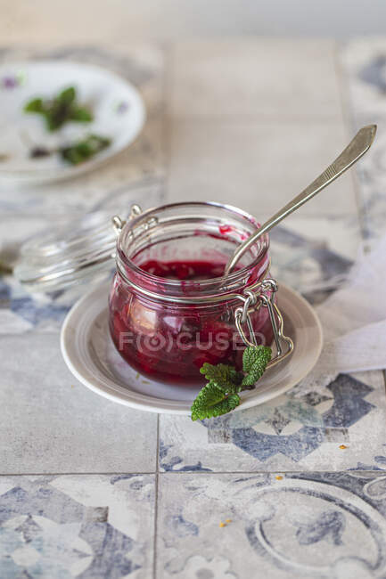 Homemade fresh cherry jam in a jar on a wooden background — Stock Photo
