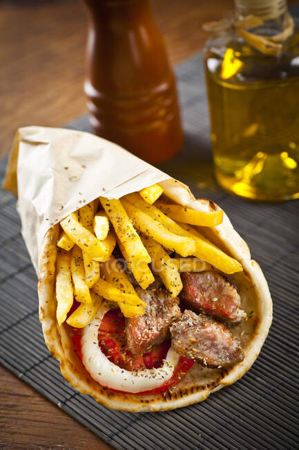 Greek pork gyros in pita with potato fries — Stock Photo