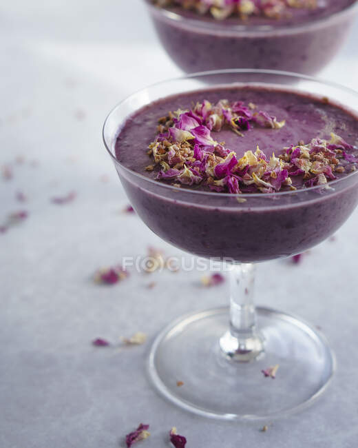 Purple blueberry smoothies in stemmed glassed — Stock Photo