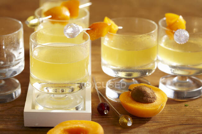 Apricot and orange liqueur with fresh fruit skewers — Stock Photo